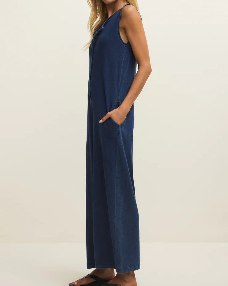 Woman wearing a blue sleeveless jumpsuit on a white background