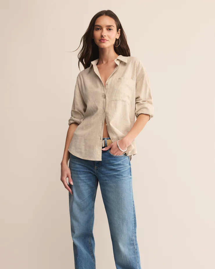 Woman wearing a beige shirt and blue jeans on a beige background