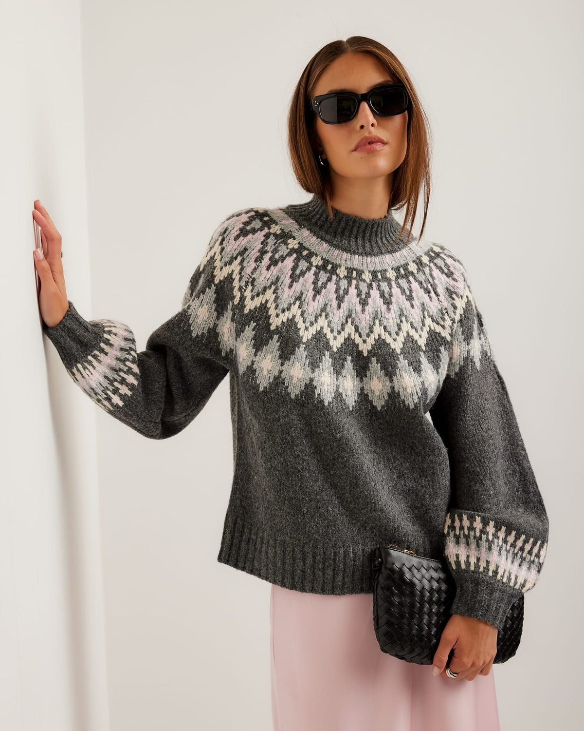 Woman wearing a gray patterned sweater against a white background