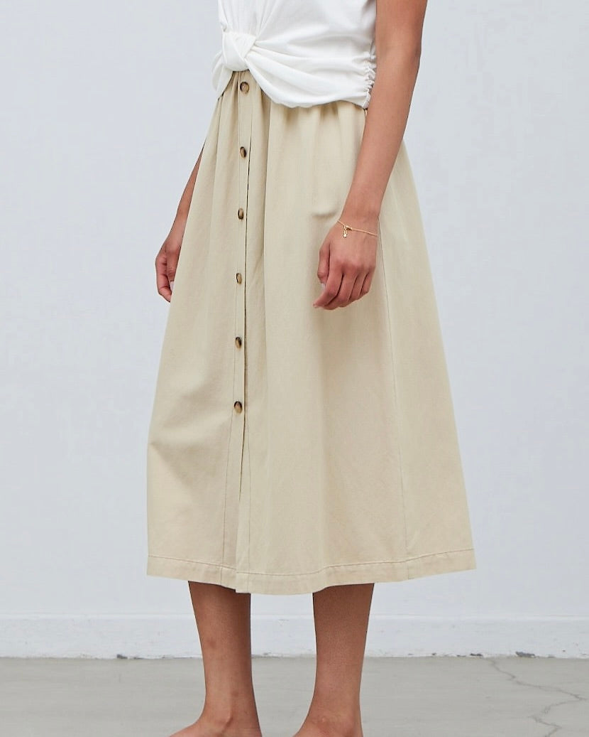 Model wearing Grade & Gather Button Down Midi Skirt in washed natural color wearing white tee on a white background