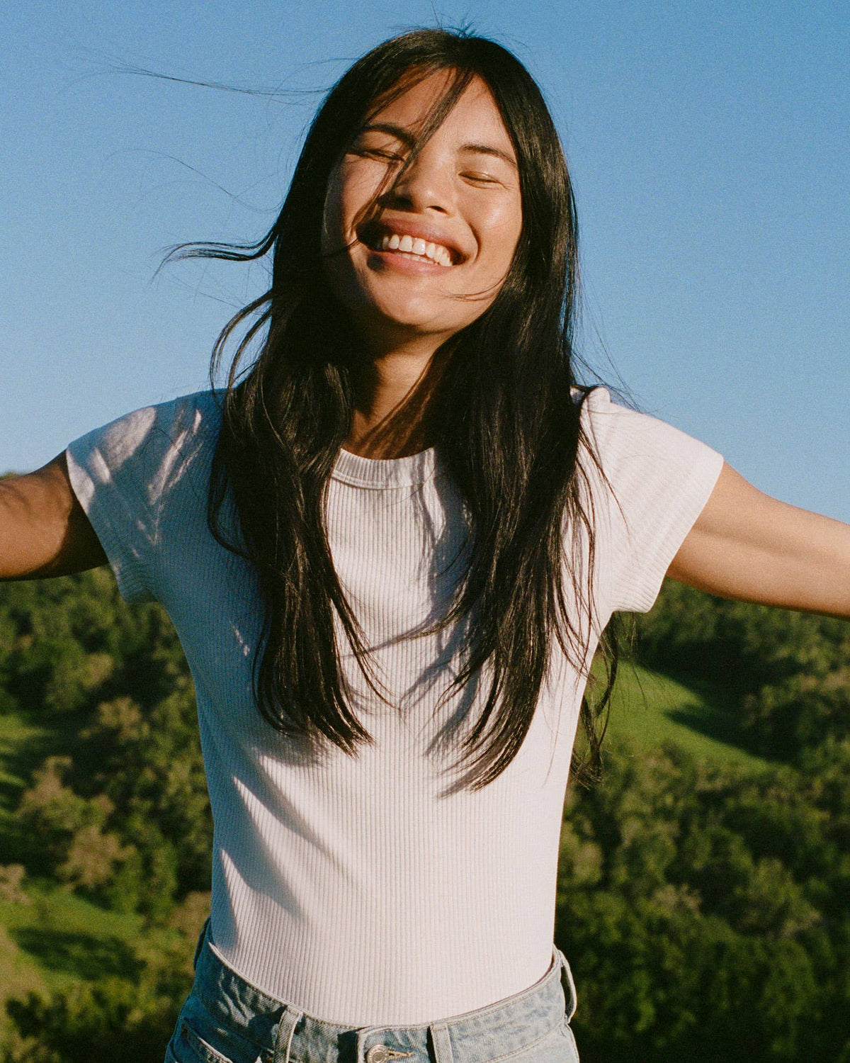 Woman with arms outstretched in a natural setting