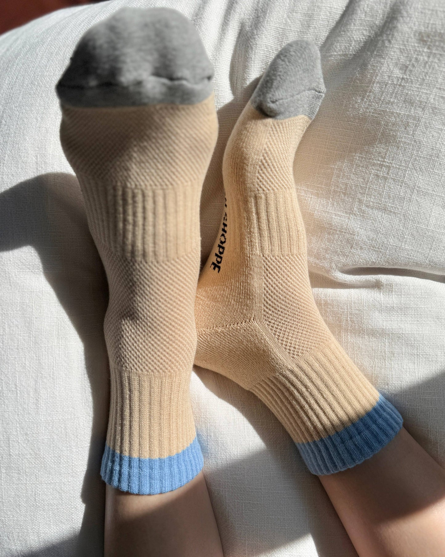 Beige socks with blue accents on a light-colored surface
