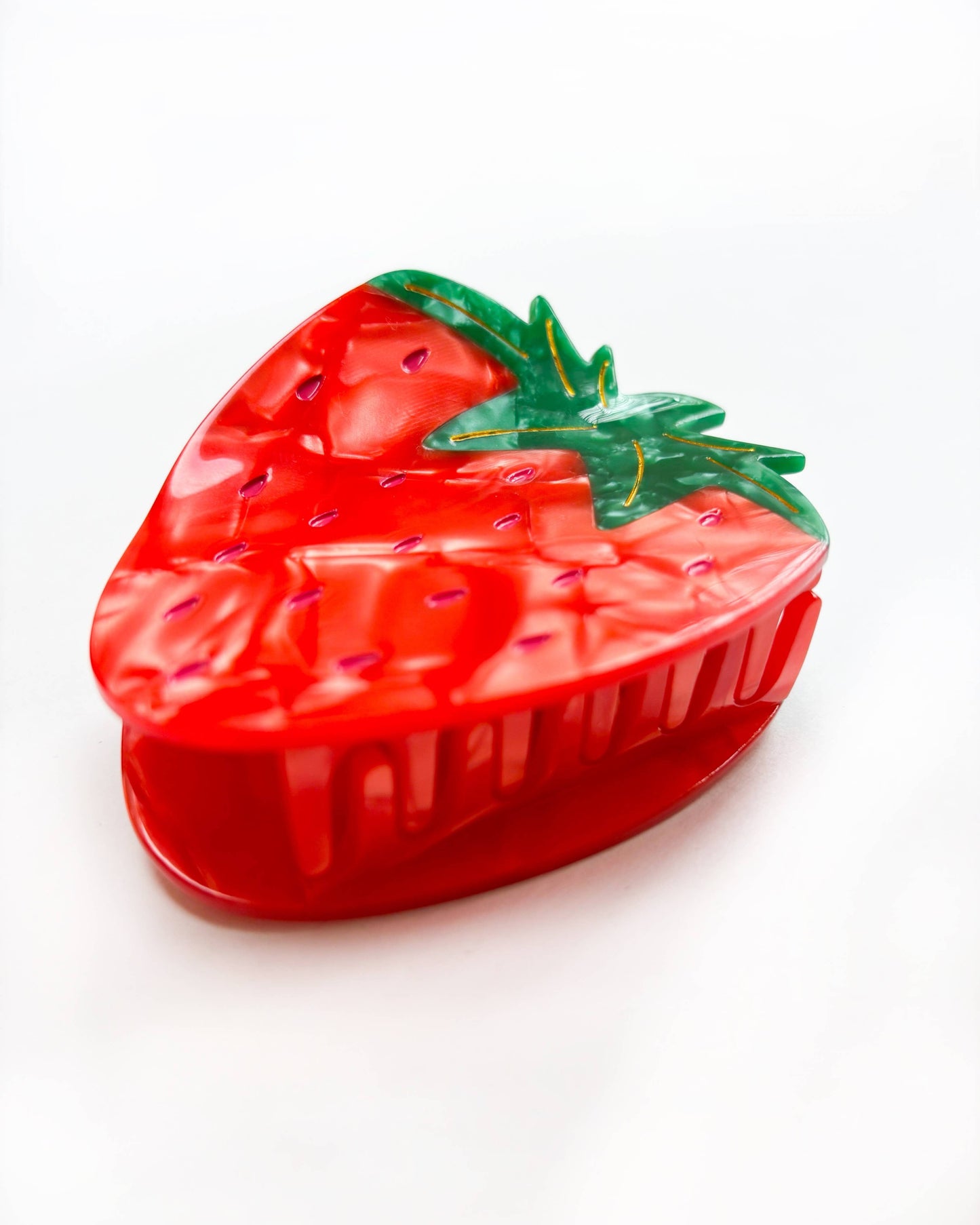 Strawberry-shaped hair clip on a white background