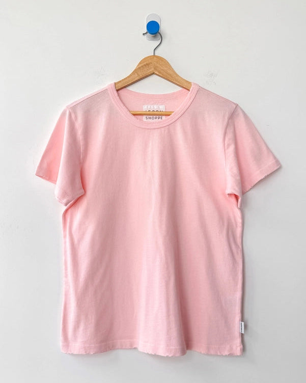 Pink t-shirt on a hanger against a gray background