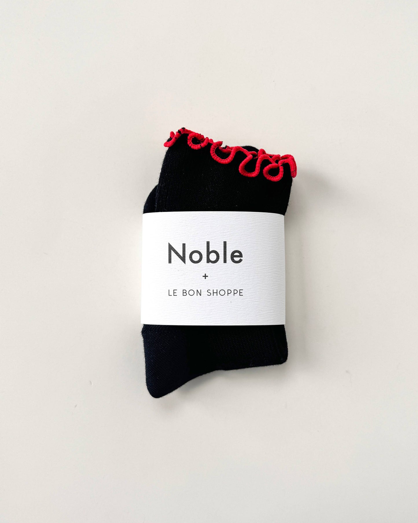 Black socks with red trim in packaging on a white background