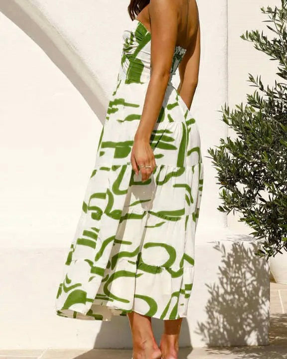  Model is wearing Rosa Clothing Twist Front Strapless Maxi Dress in green with white sandals on a white background