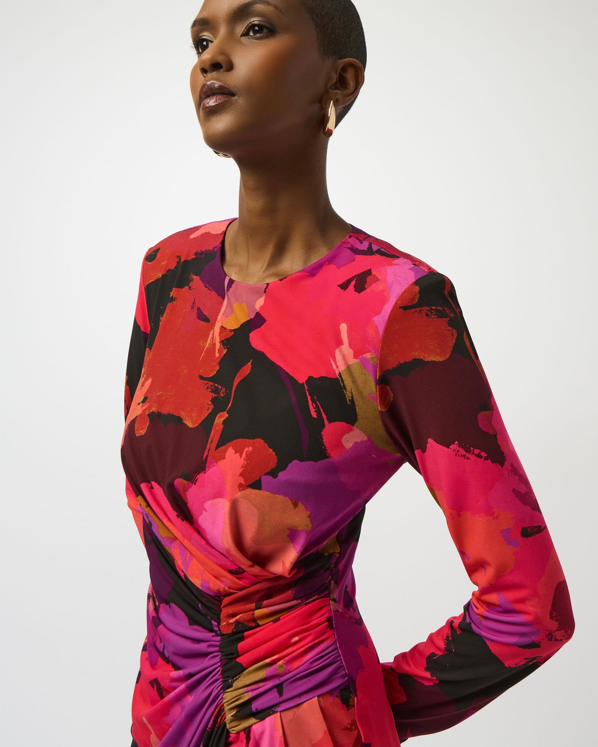 Model is wearing Joseph Ribkoff Silky Knit Floral Print Sheath Dress in color Black Multi. Model is posed on white background. 