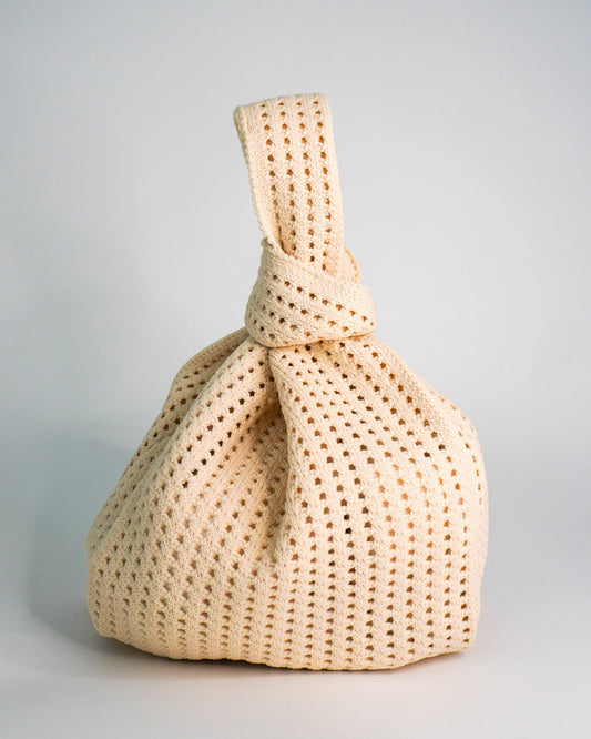 Beige woven handbag on a light gray background