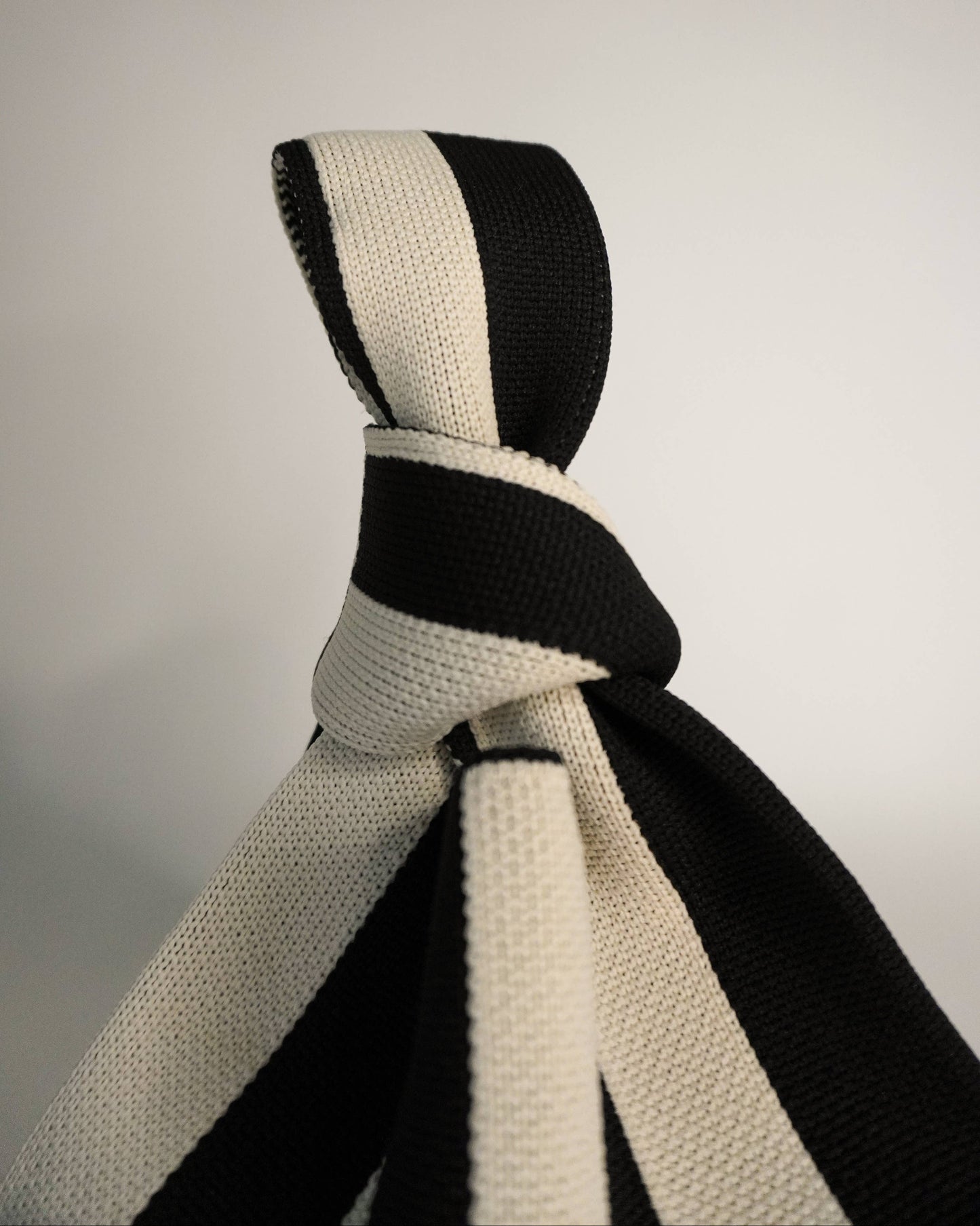 Black and white striped tie on a light gray background