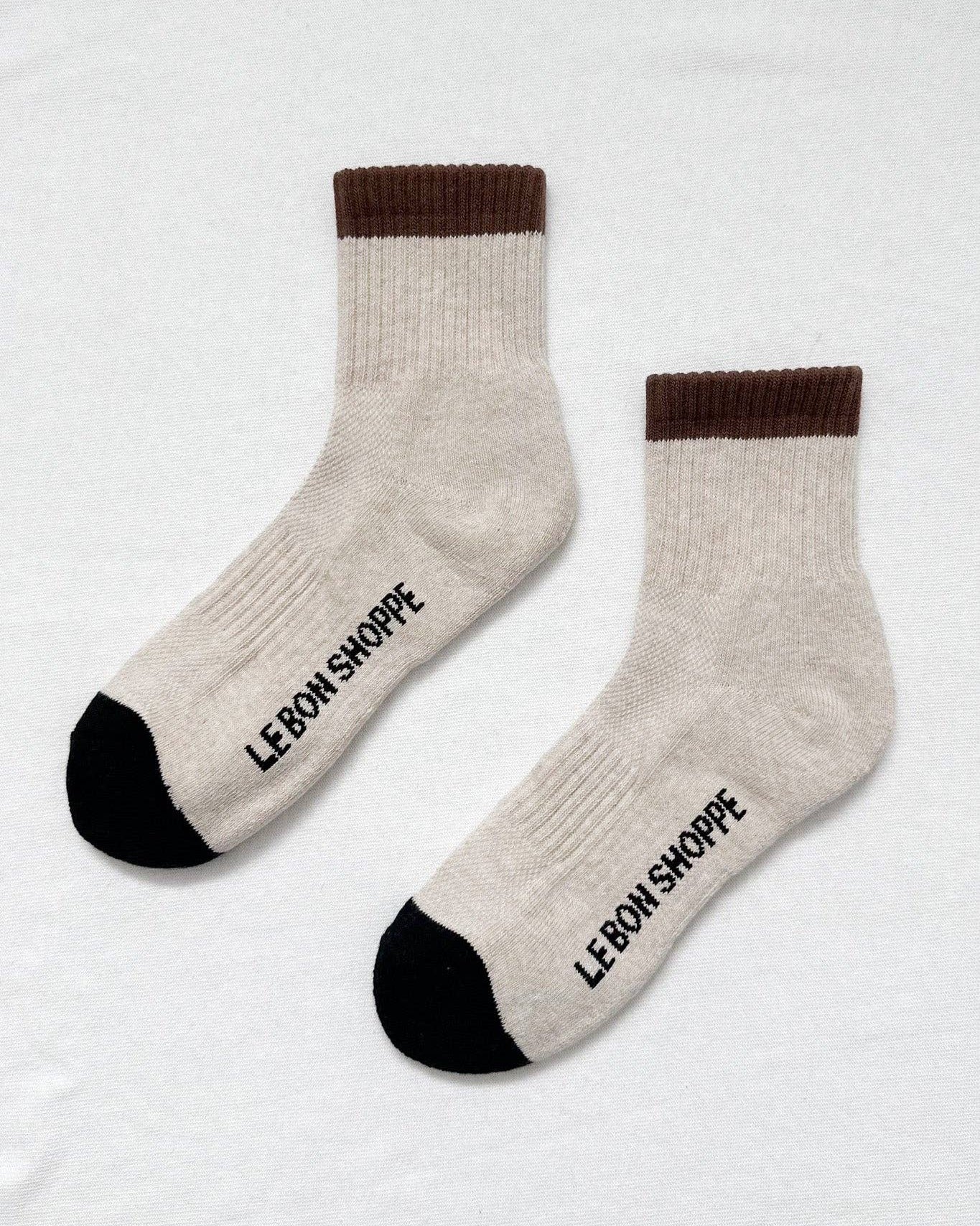 Pair of socks with brown cuffs and black toes on a white background