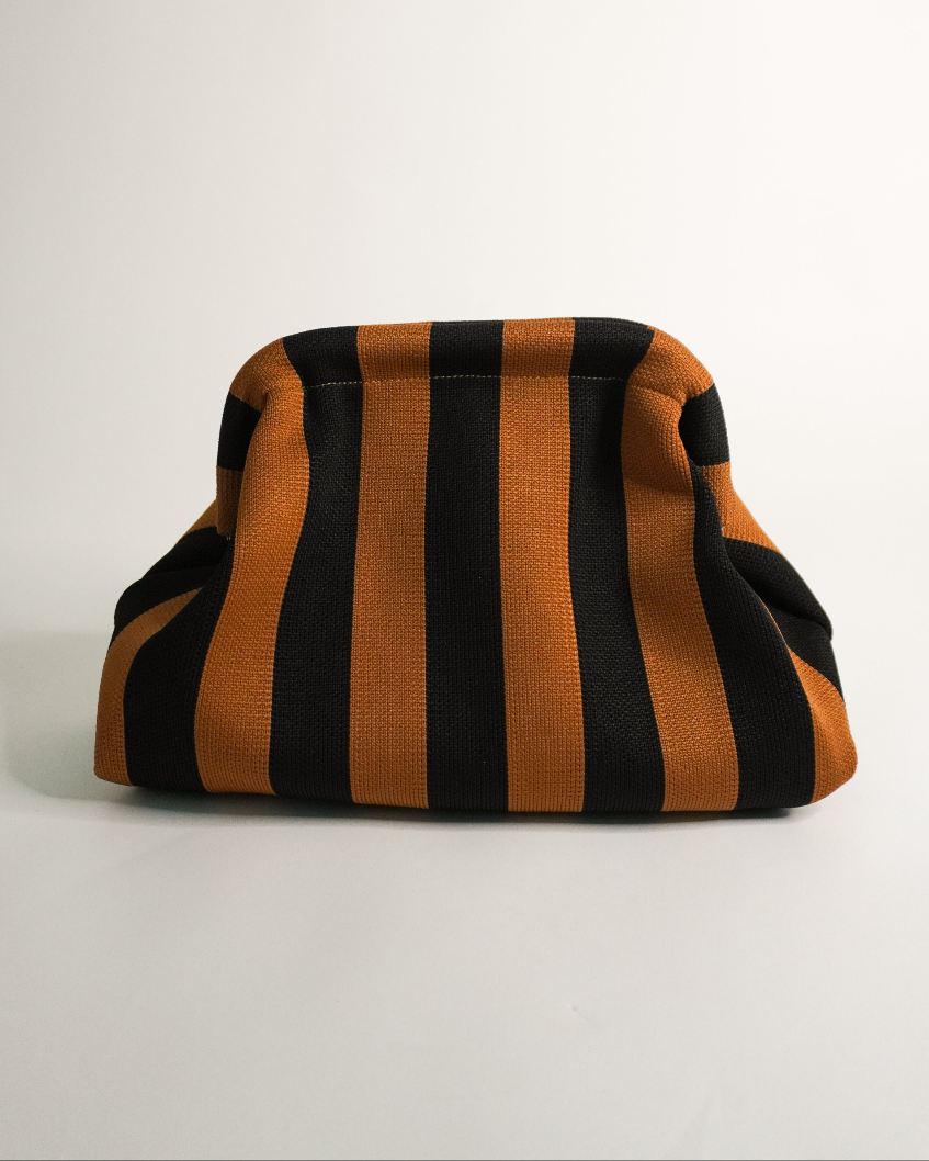 Striped bag with black and orange horizontal stripes on a light gray background