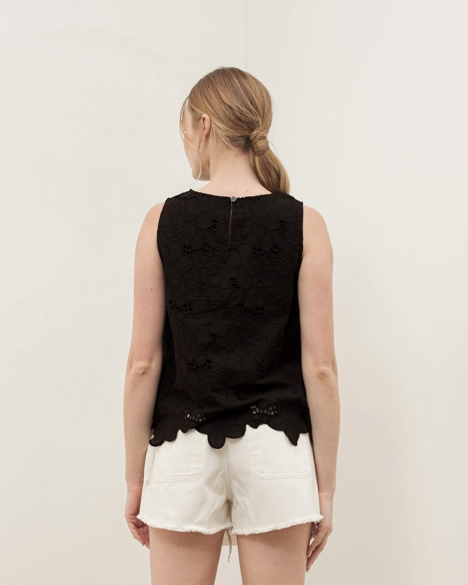 Back view of the Aaron & Amber flower embroidered sleeveless top in black worn by a model standing in front of a white background.