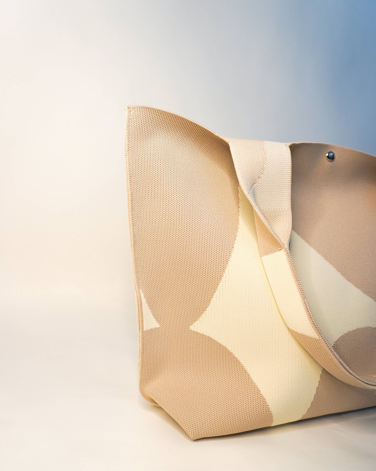 Beige handbag with a subtle pattern on a light background