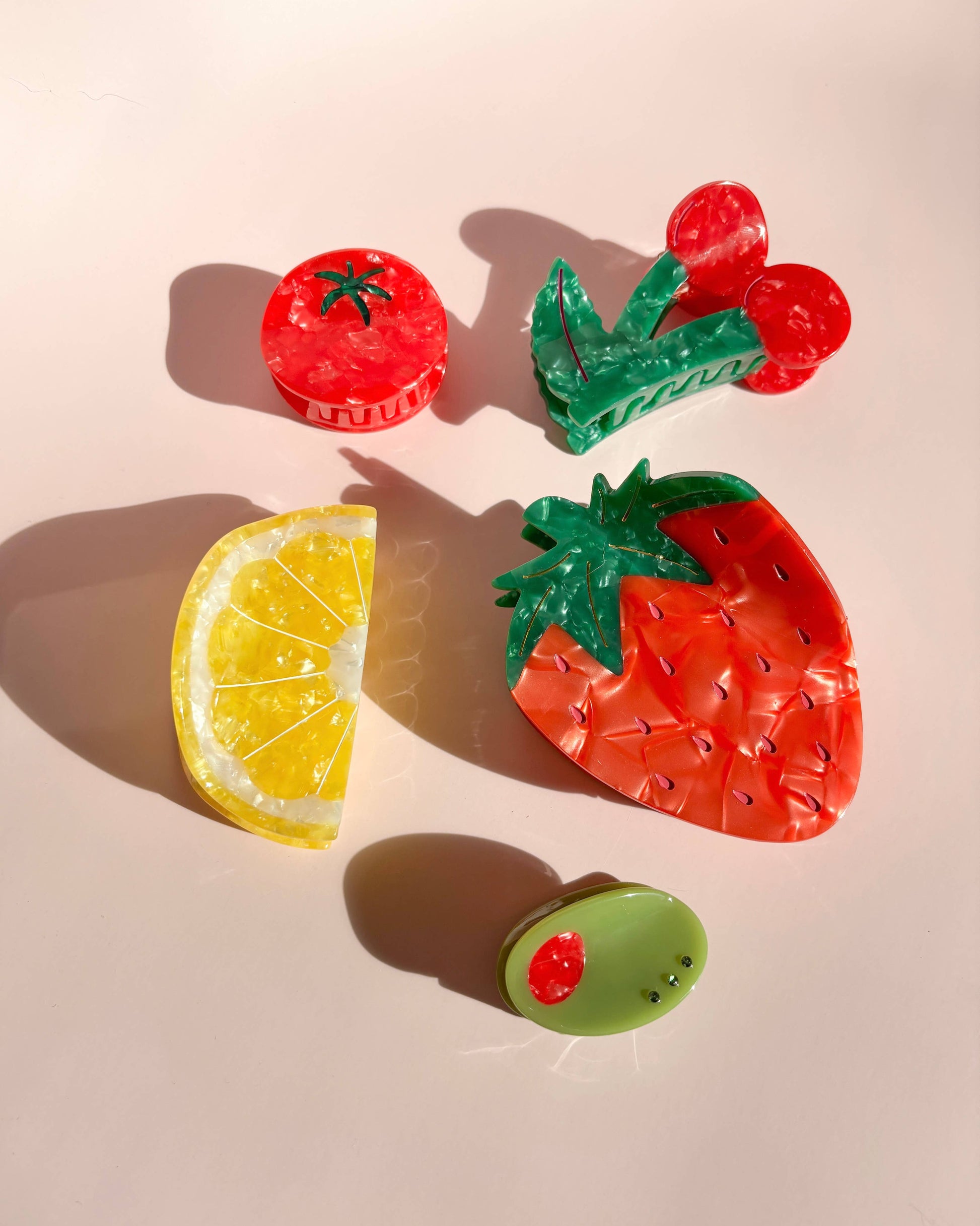 Fruit-shaped hair clips on a light pink background