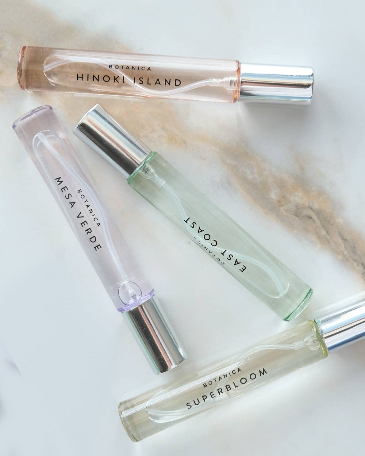 Four perfume bottles with visible branding on a light background