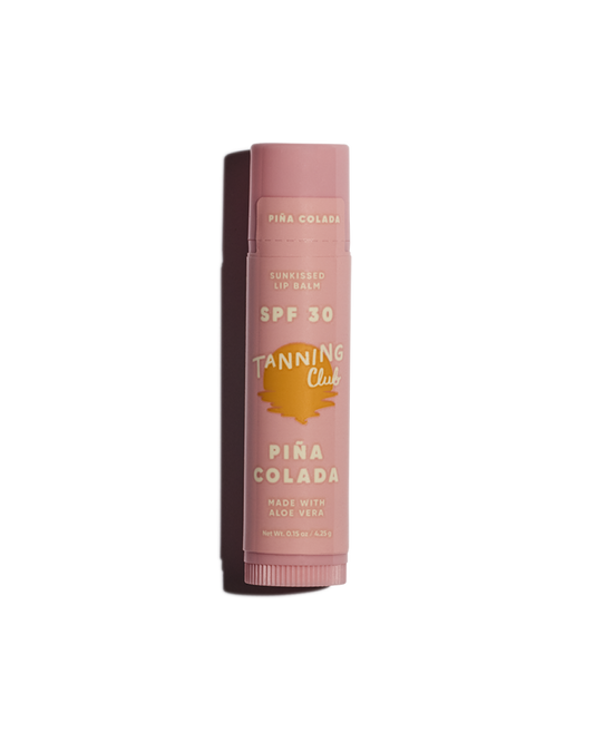 Pink lip balm with 'Tanning Club' branding on a white background