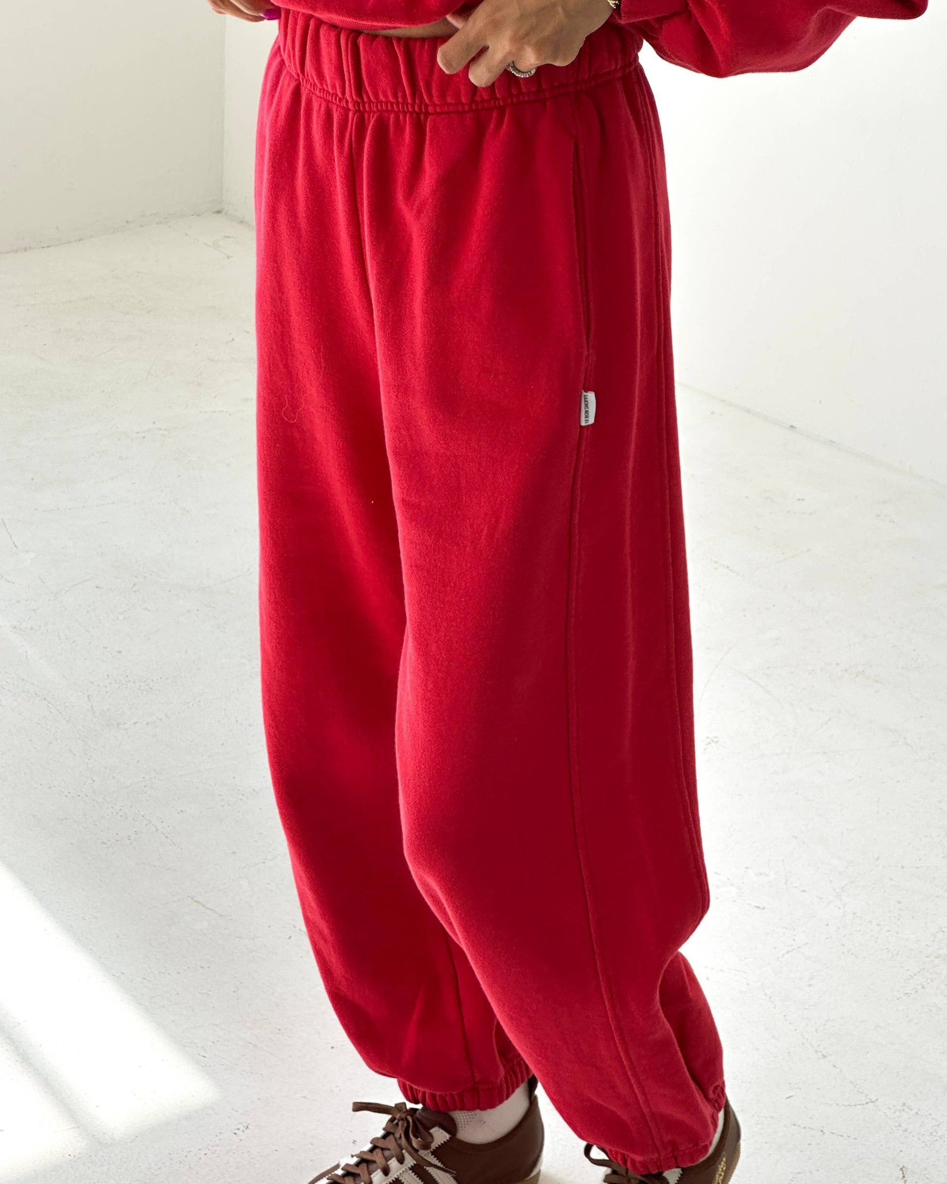 Red tracksuit with brown shoes on a white floor