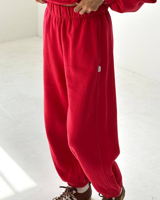 Red tracksuit with brown shoes on a white floor