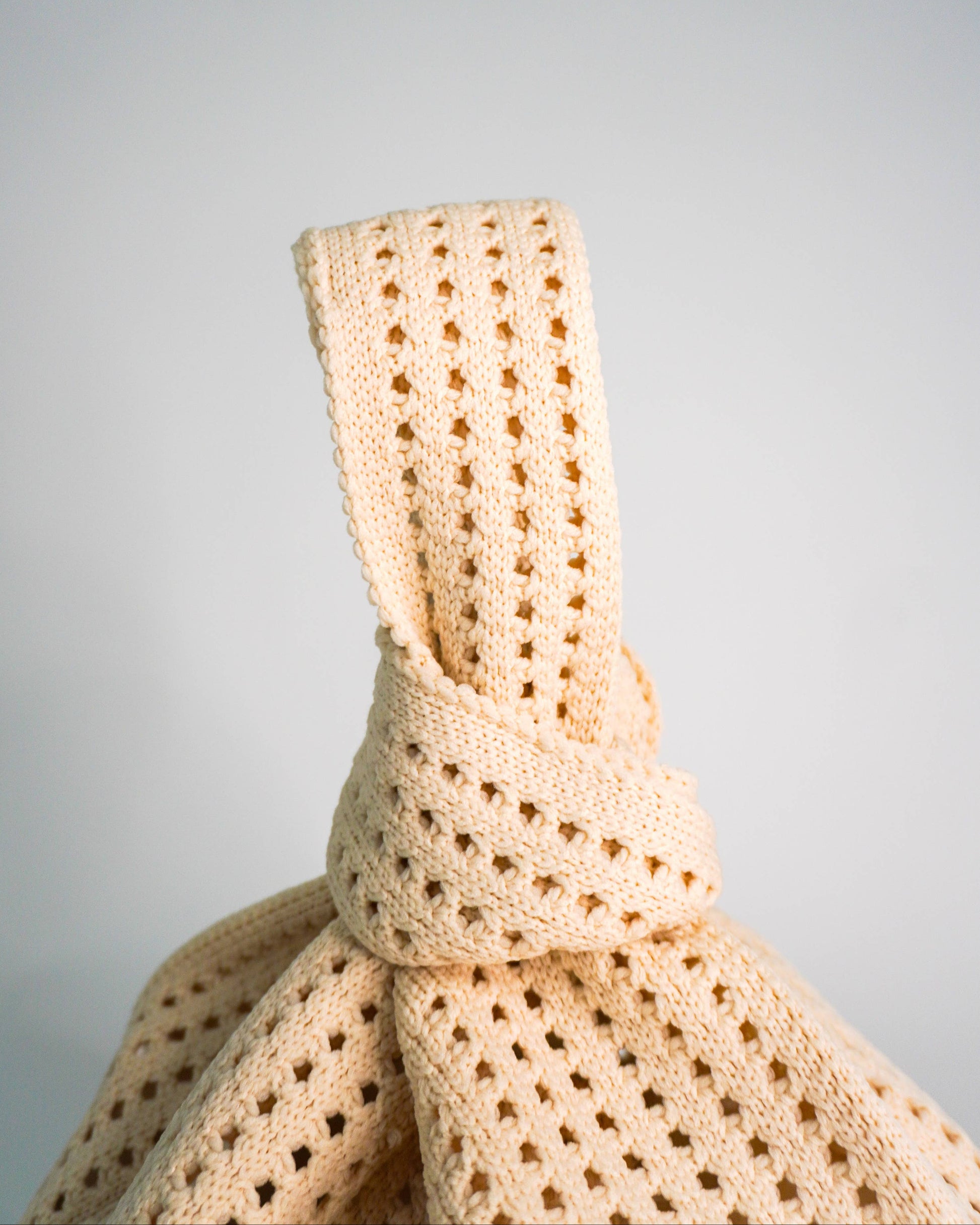 Beige crochet fabric on a light gray background