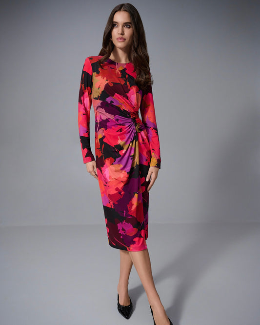 Model is wearing Joseph Ribkoff Silky Knit Floral Print Sheath Dress in color Black Multi. Model is wearing black heels on a white background. 