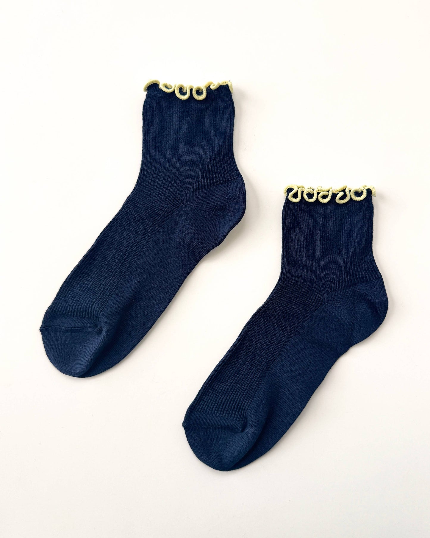 Pair of navy blue socks with gold accents on a white background