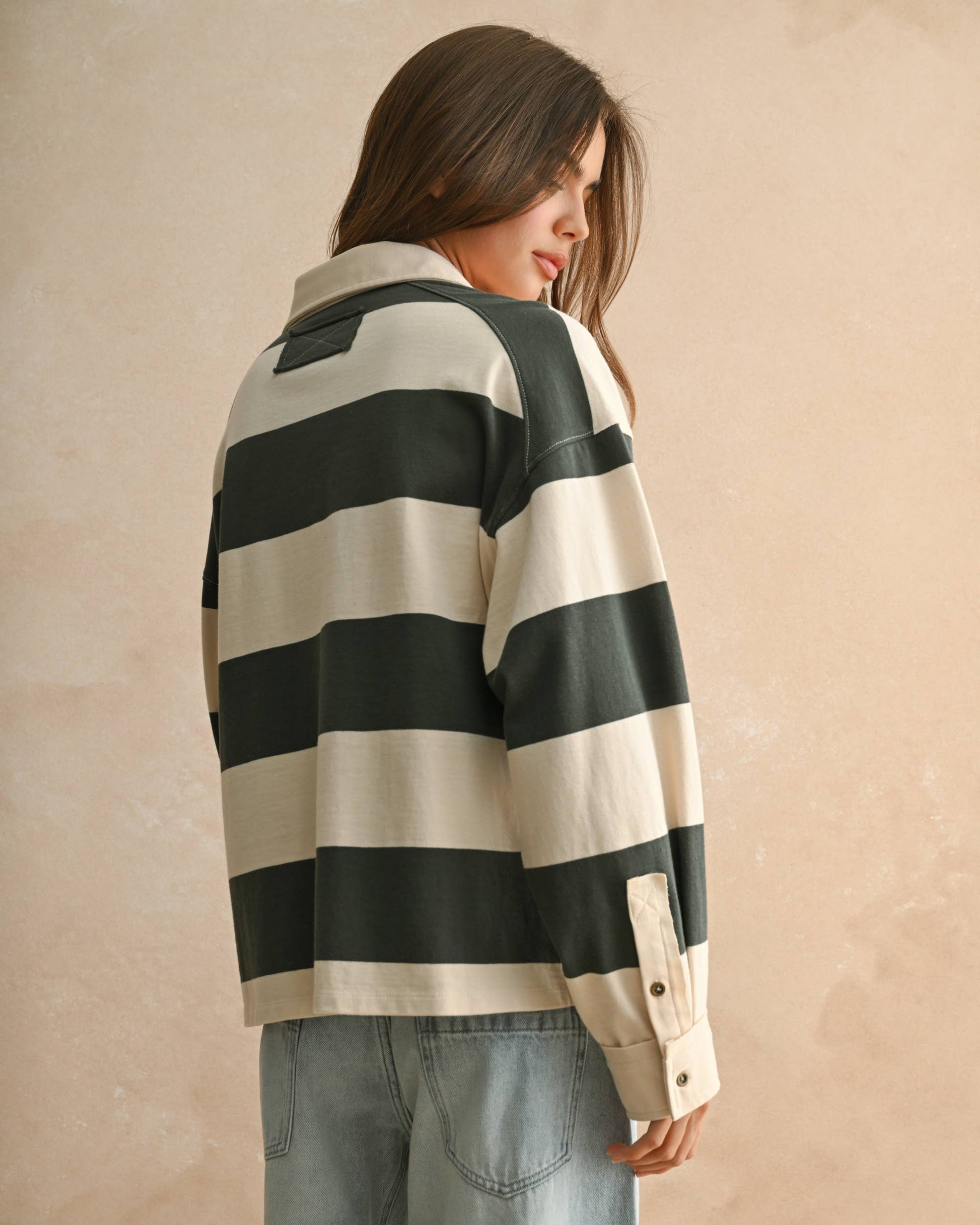Person wearing a green and white striped shirt with a beige background