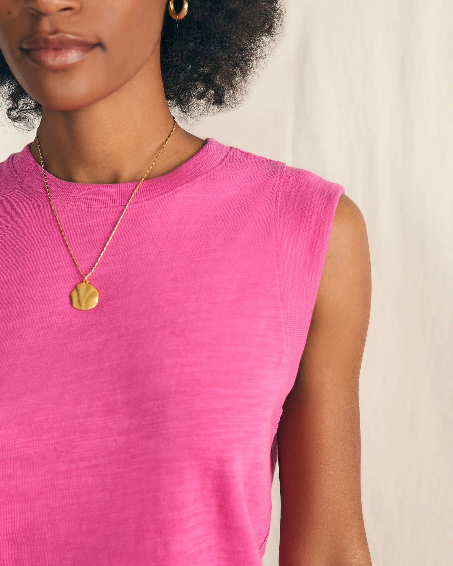 Model wearing Faherty Sunwashed Slub Muscle Tank in cone flower pink wearing necklace on a white background