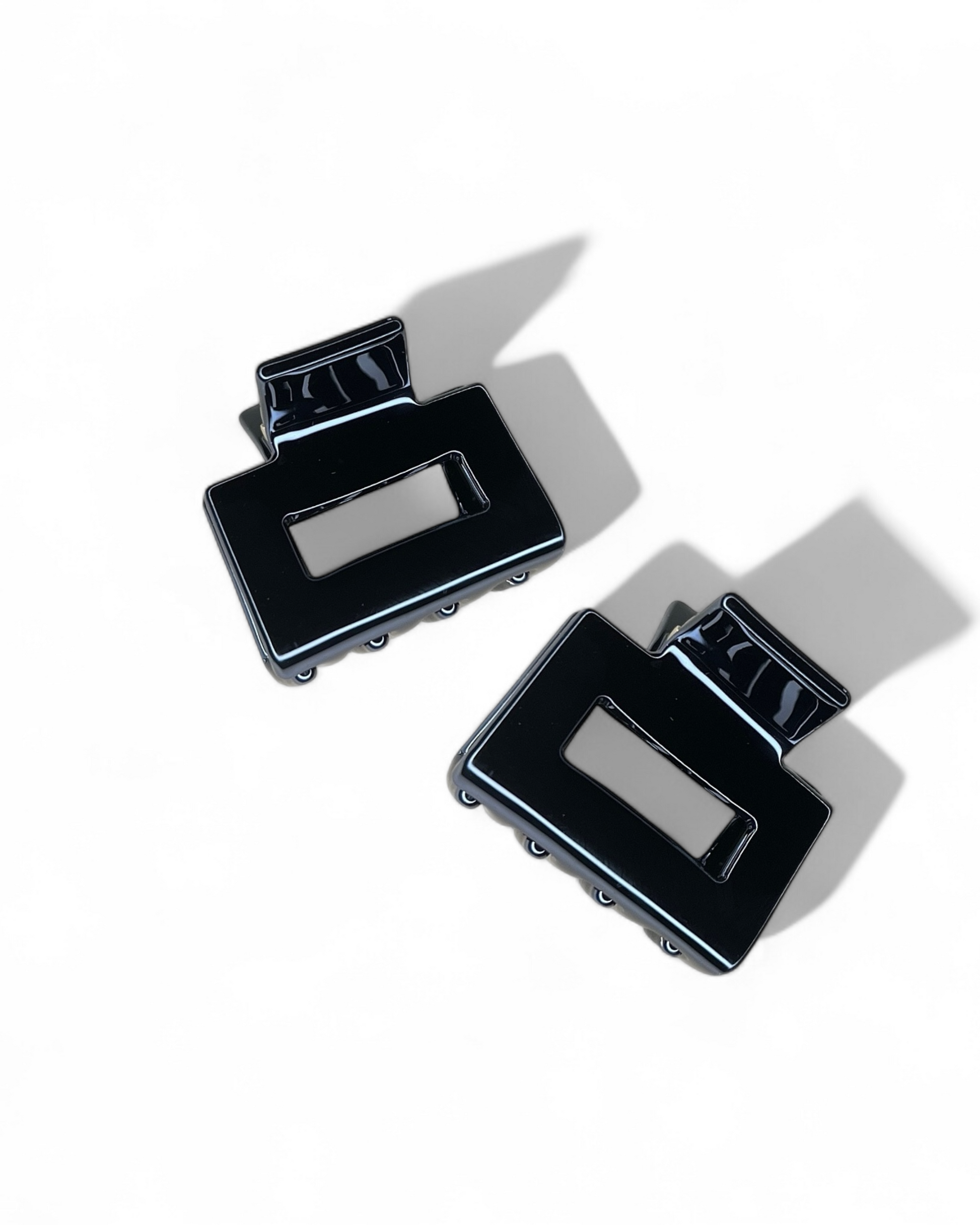 Pair of black hair clips on a white background