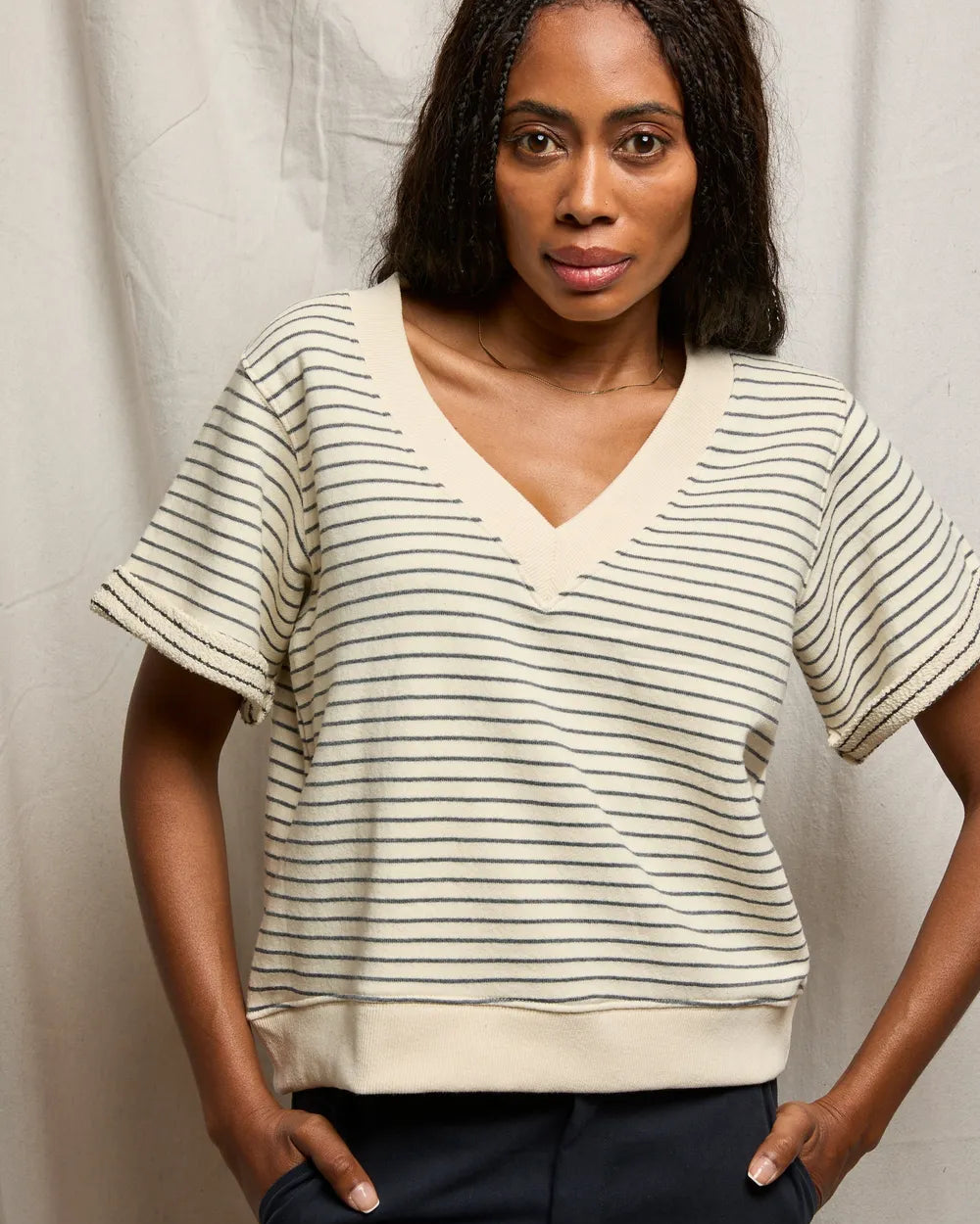 Woman wearing a striped shirt against a plain background