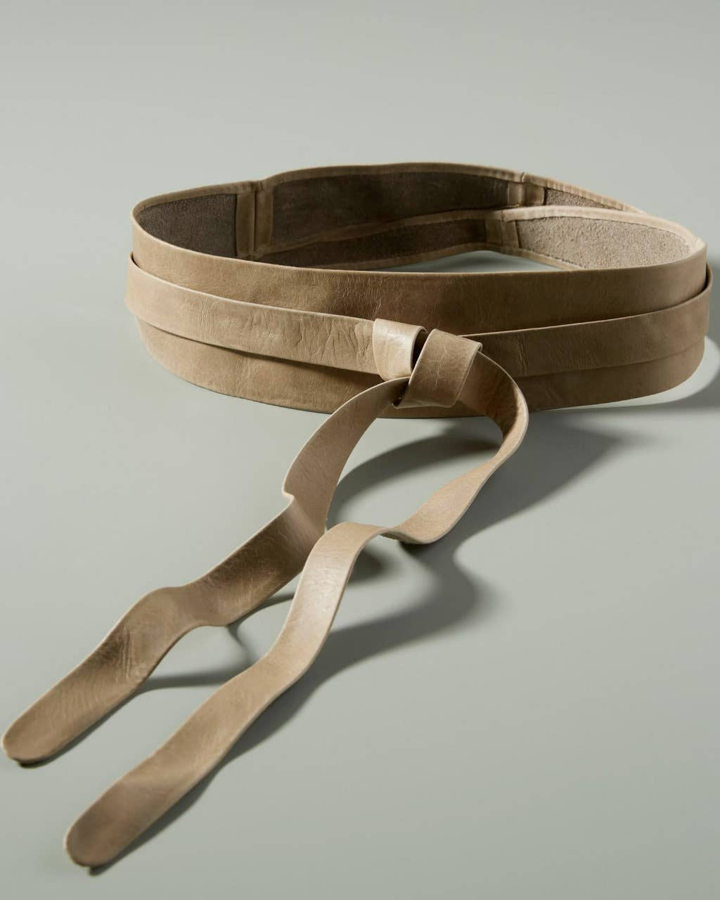 Brown leather belt on a light gray background