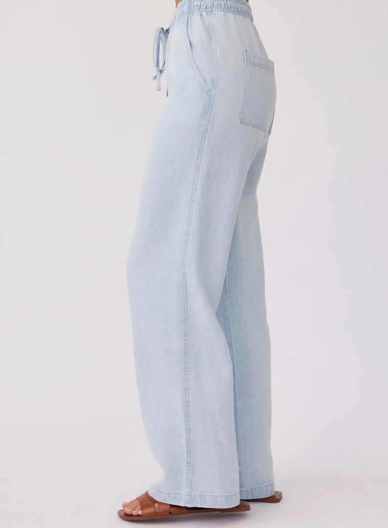 Model is wearing Bella Dahl Drawstring Pant in color Oasis Spray Wash with brown leather sandals on a white background
