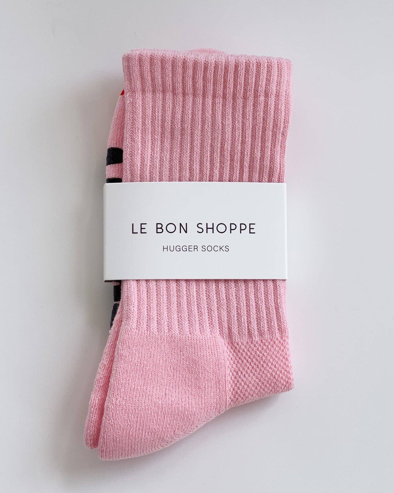 Pink socks with a white label on a light gray background
