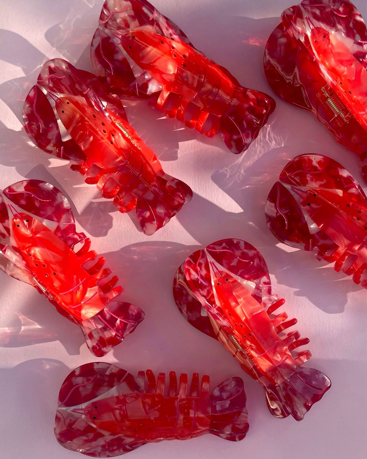 Red lobster-shaped hair clips on a white background