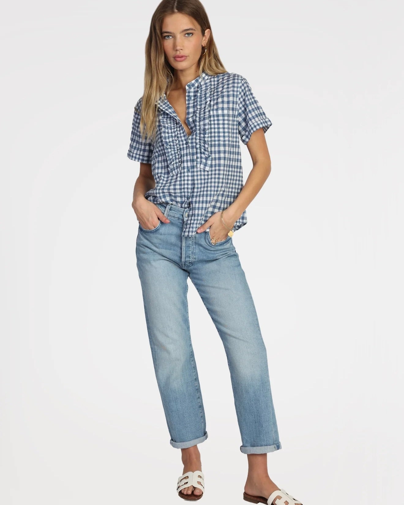 Model wearing Dylan Harper Ruffle Blouse in blue and white wearing jeans on a white background