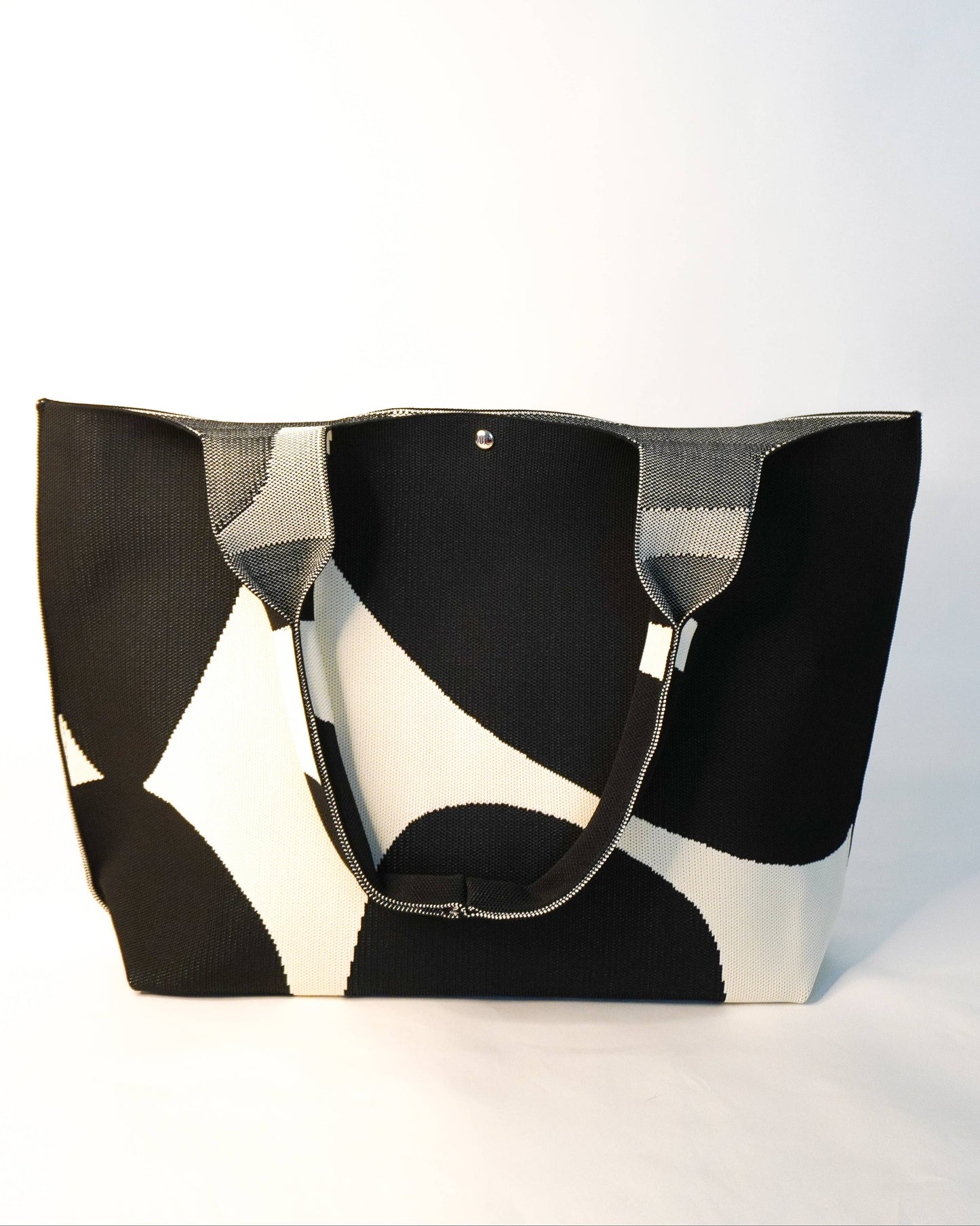 Black and white patterned tote bag on a light gray background