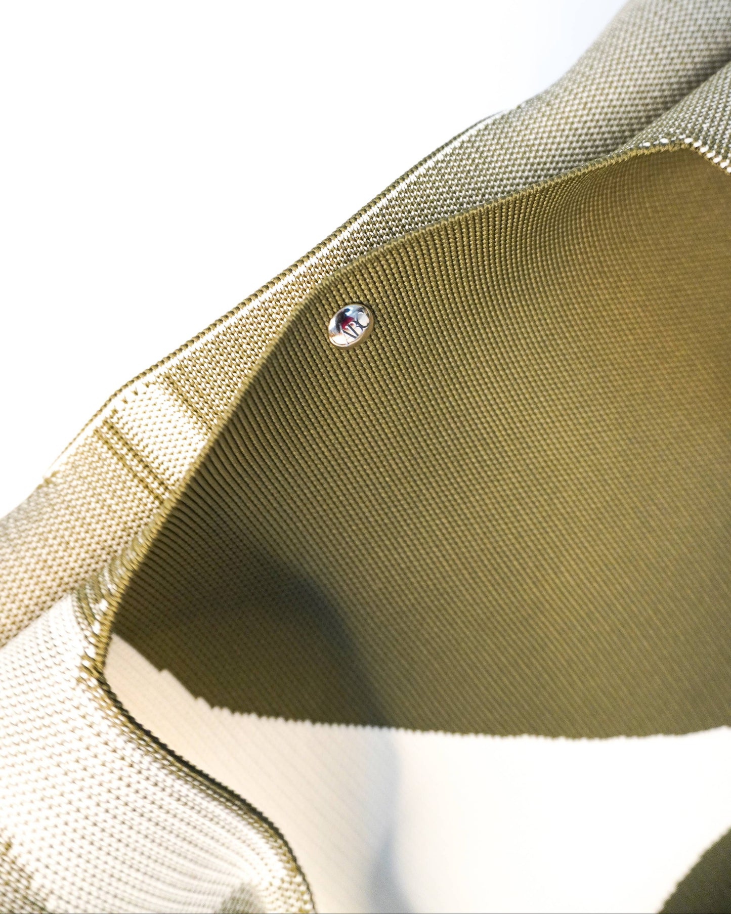 Close-up of a gold fabric with a small crystal embedded in it.