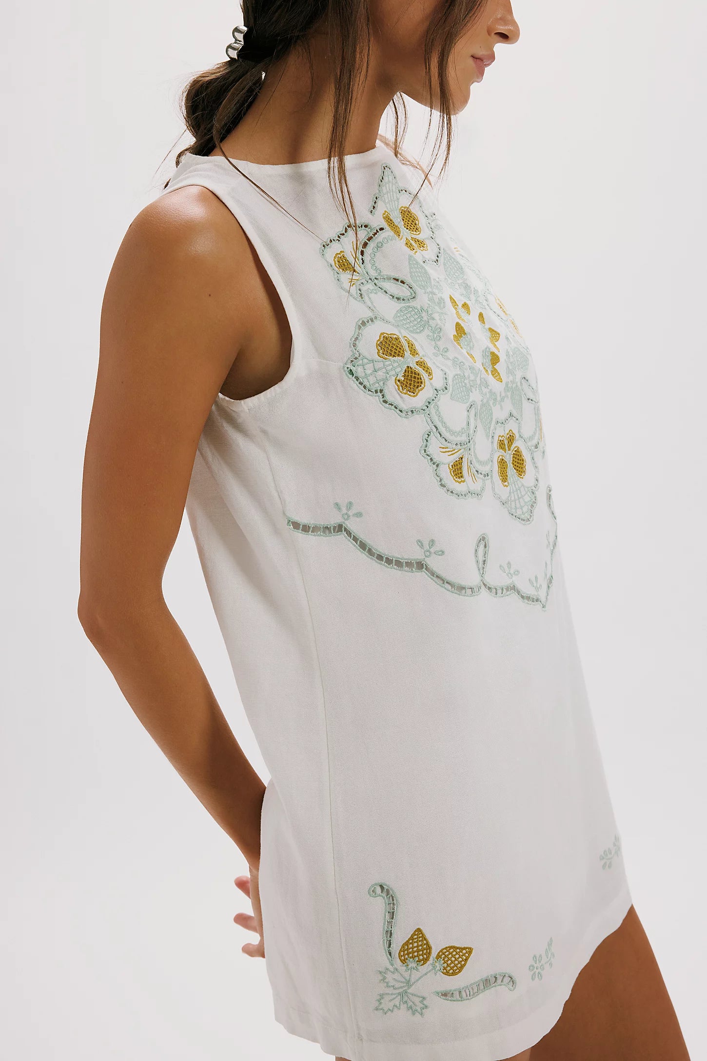 White sleeveless top with floral embroidery on a white background