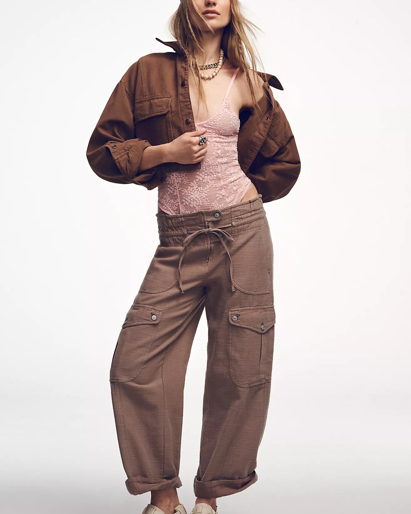 Woman wearing a brown jacket and pants on a white background