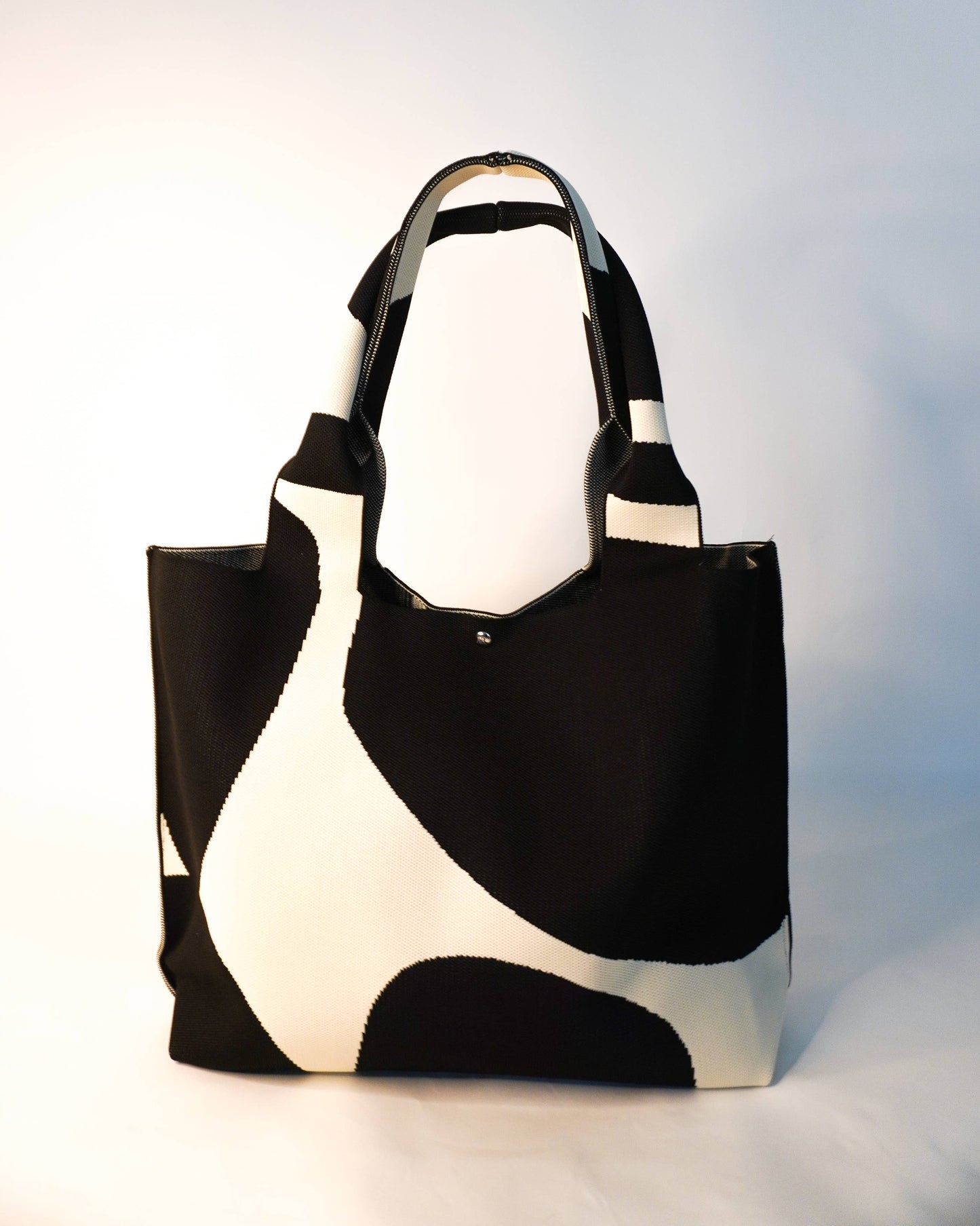 Black and white tote bag on a light gray background