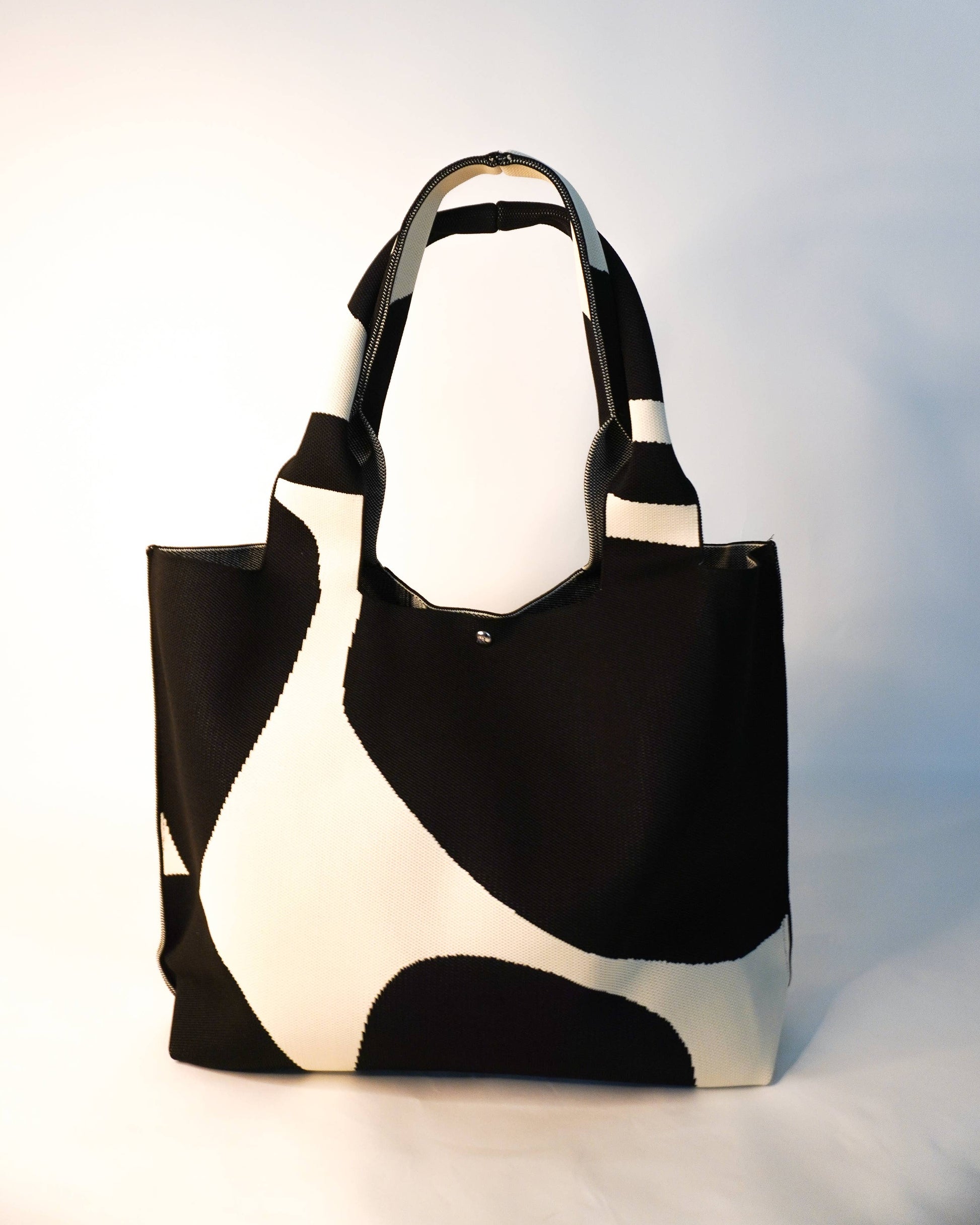 Black and white tote bag on a light gray background