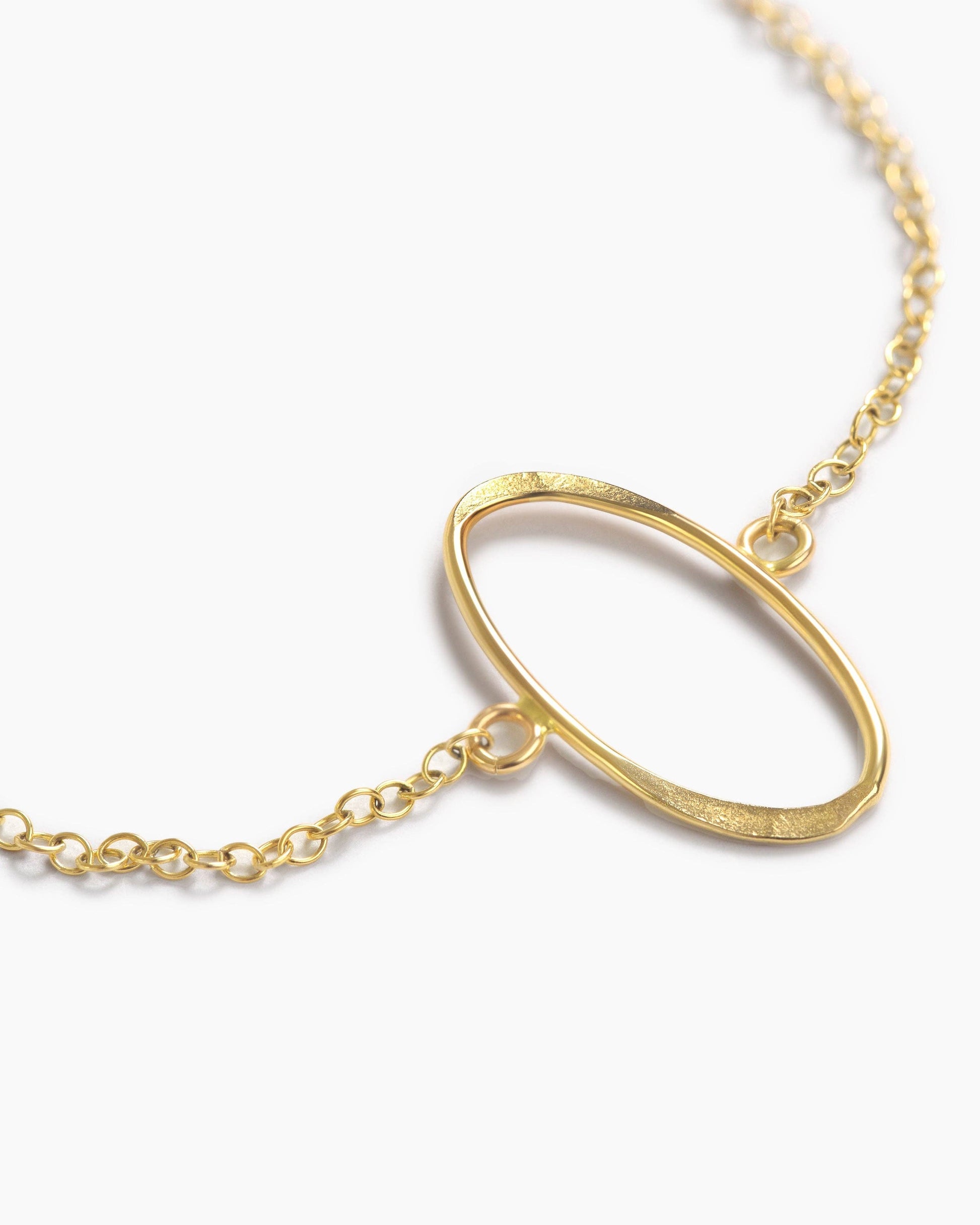 Gold necklace with a unique pendant on a white background