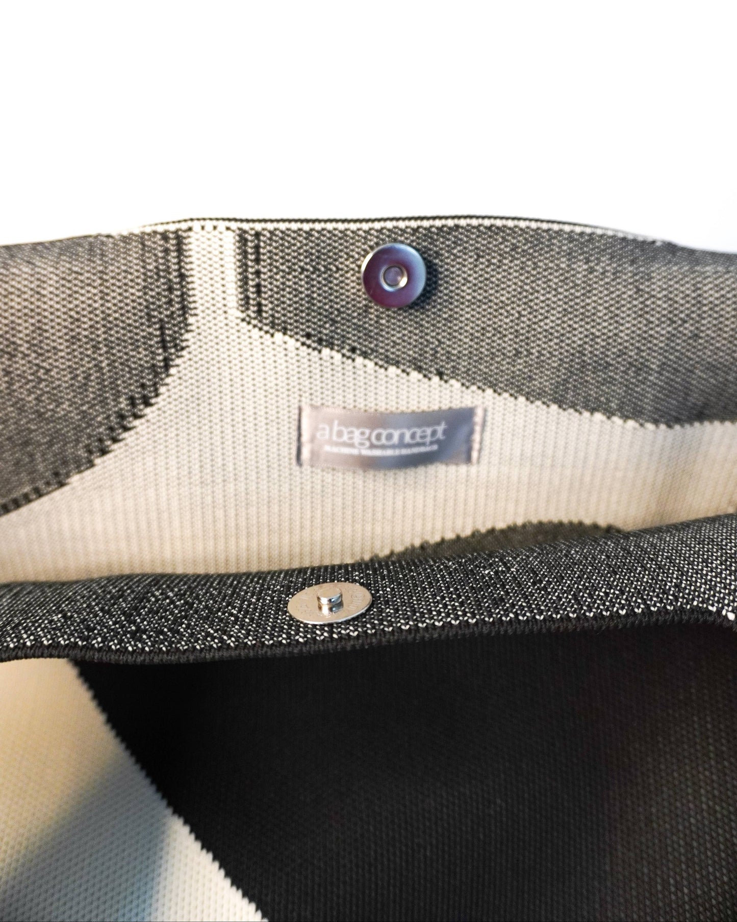 Close-up of a gray fabric product with a brand label on a white background