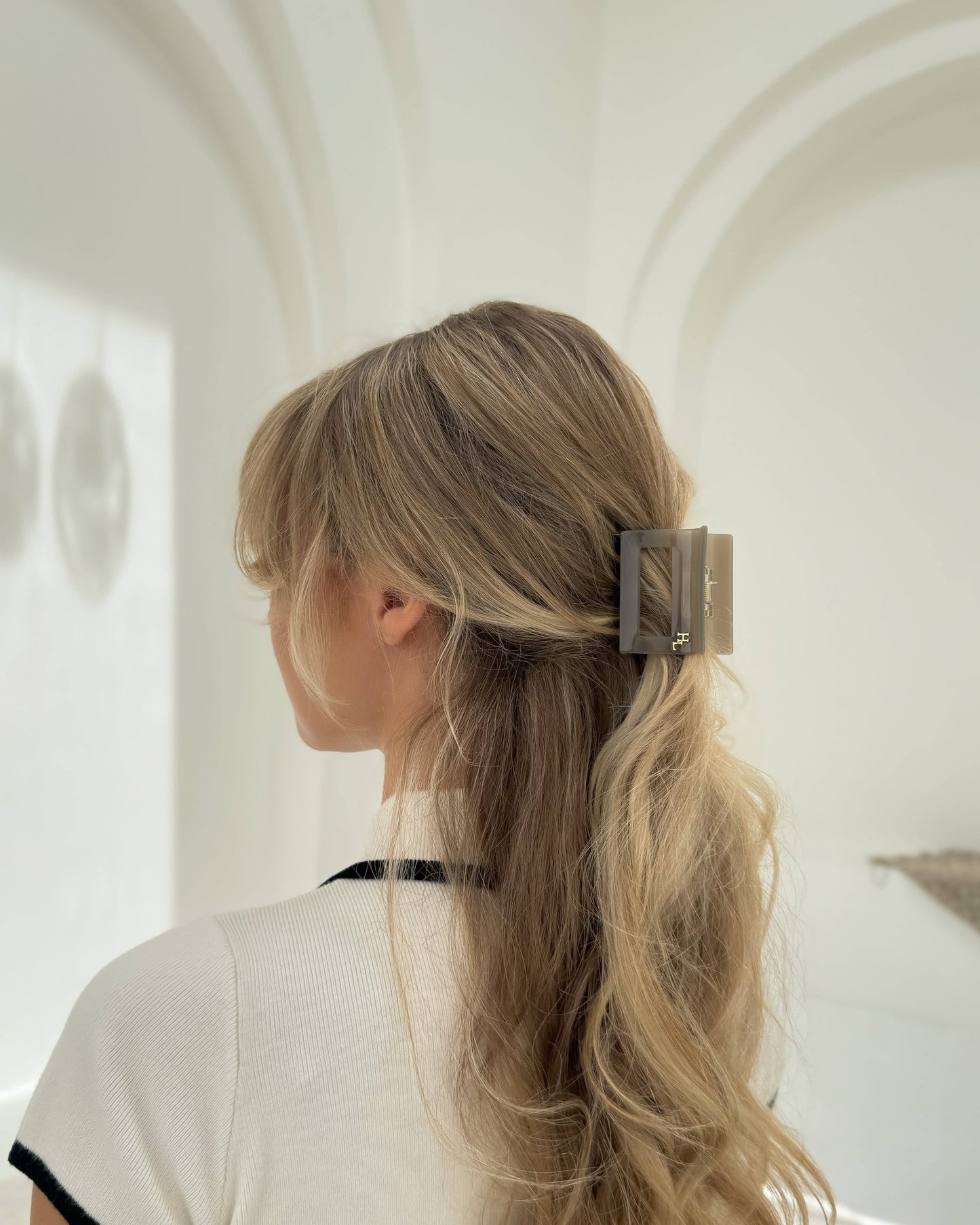 Woman with blonde hair wearing the HoneyLux Dolce Midi Acetate Claw clip in the color Capri Stone against a neutral background.