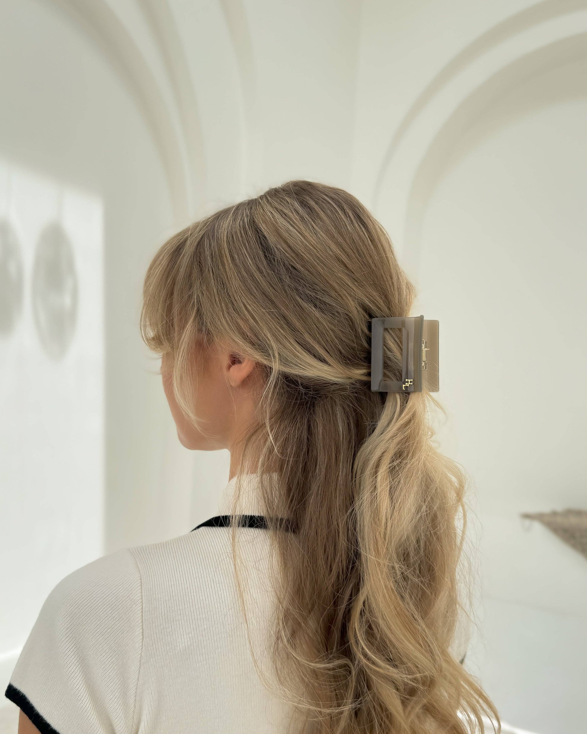 Woman with blonde hair wearing the HoneyLux Dolce Midi Acetate Claw clip in the color Capri Stone against a neutral background.
