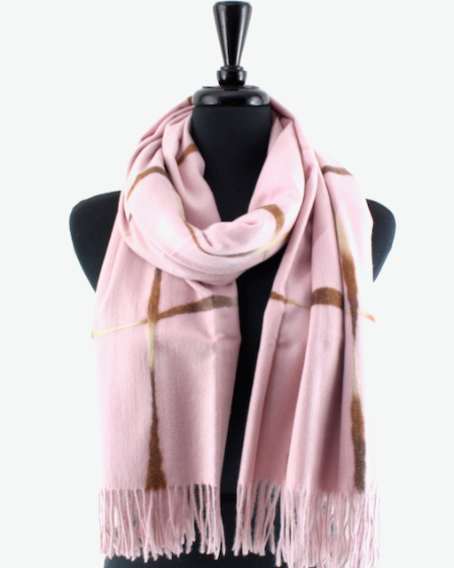 A light pink knit scarf with brown abstract brushstroke patterns and fringed ends, draped on a black mannequin torso against a plain white background.