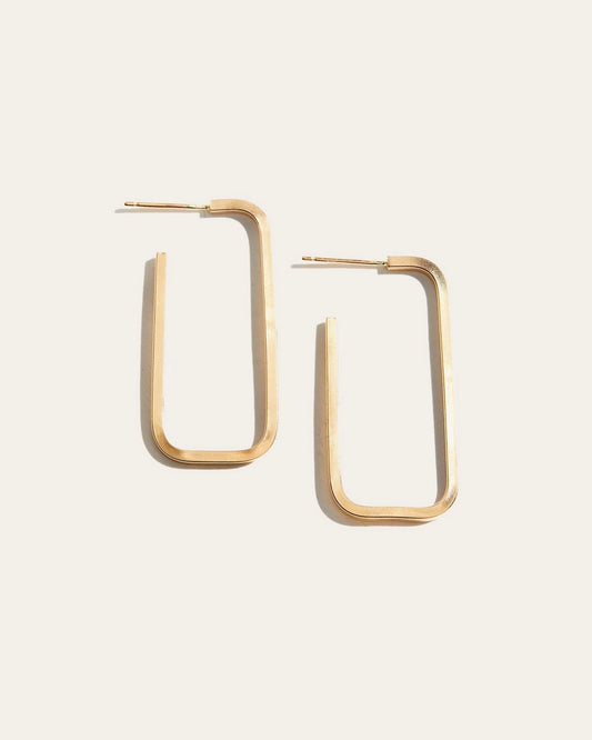 Close up of the Able Bali Hoops in gold laying against an off-white background 