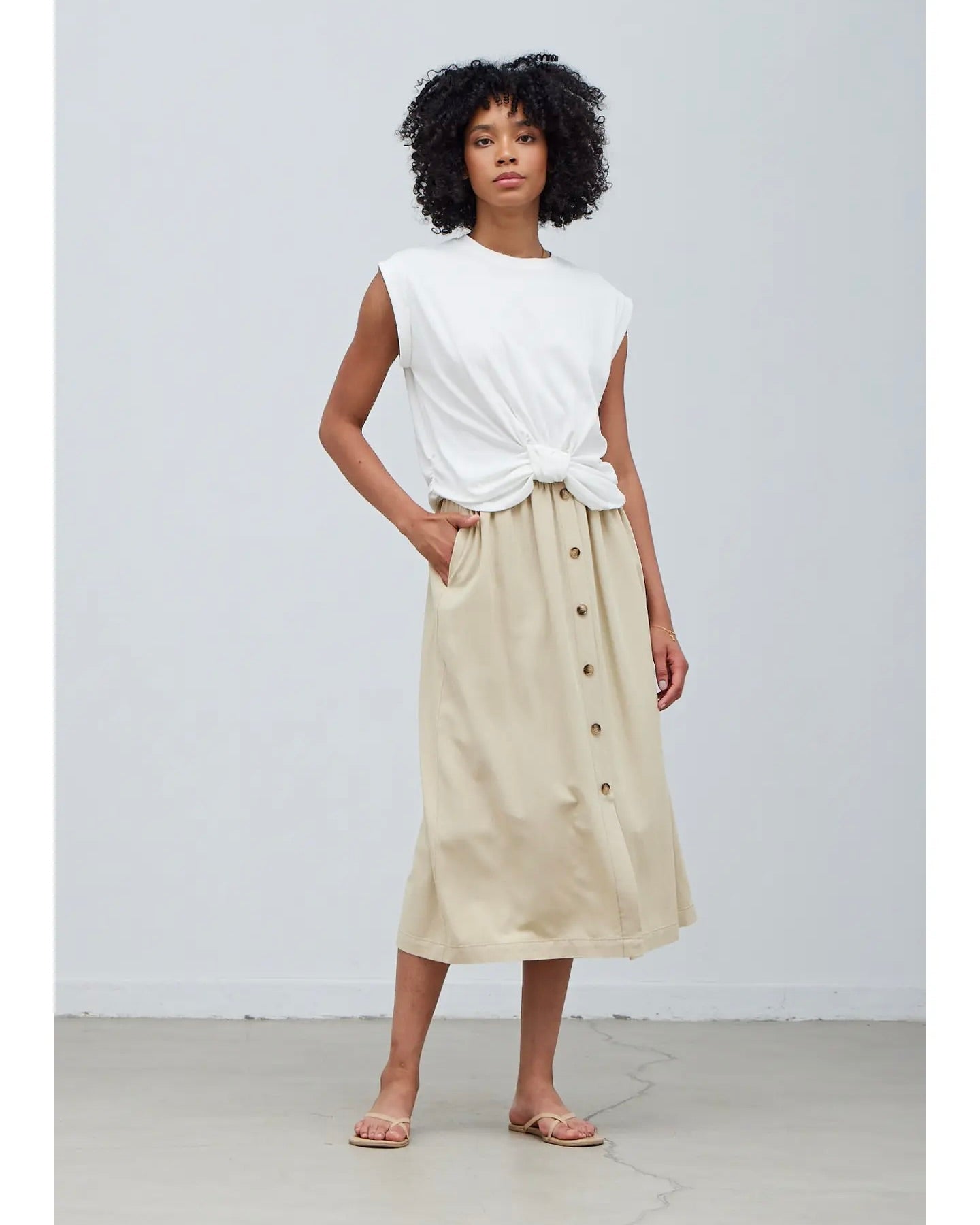 Model wearing Grade & Gather Button Down Midi Skirt in washed natural color wearing white tee on a white background