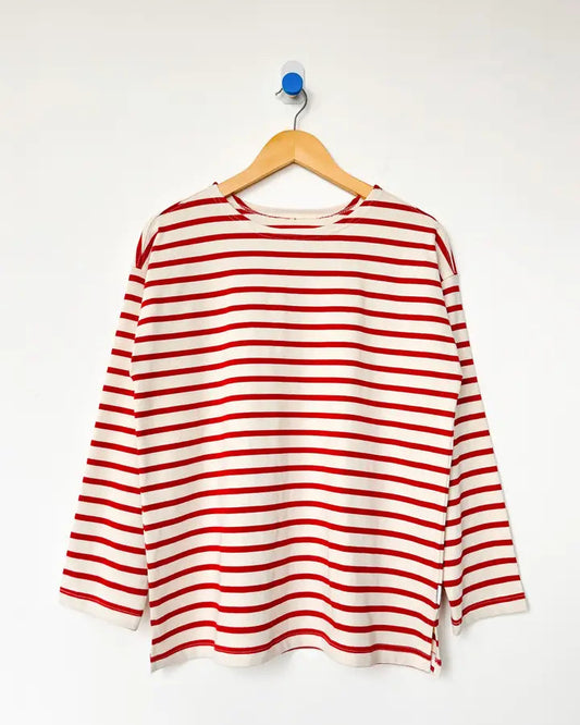 Red and white striped shirt on a hanger against a white background