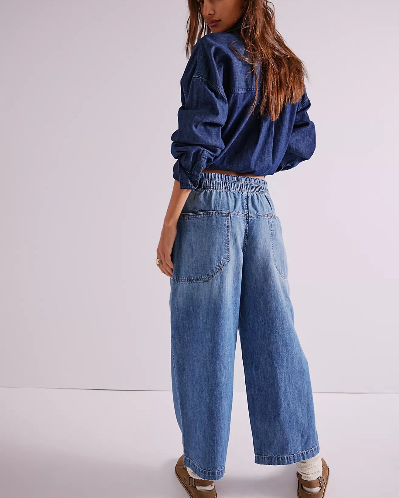 Woman wearing a blue denim outfit on a white background