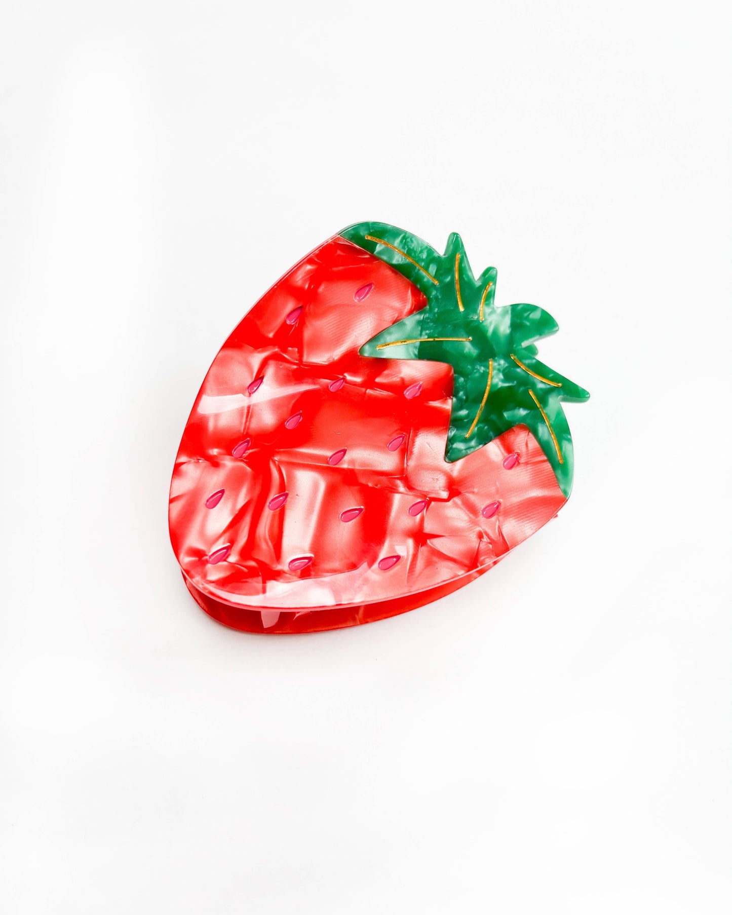 Strawberry-shaped hair clip with red and green colors on a white background